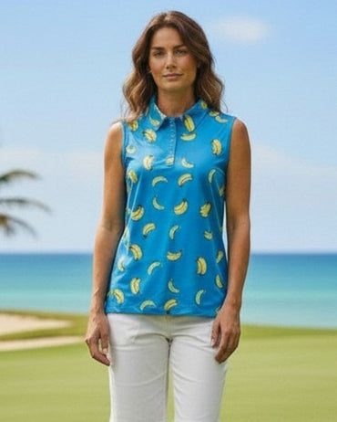 Woman in a blue sleeveless top with yellow patterns and white shorts standing on a golf course.